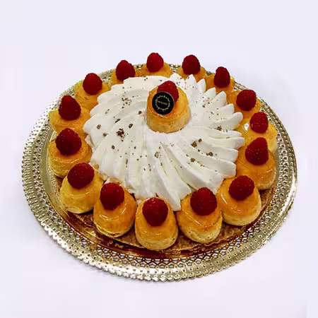 Uma sobremesa decorativa com natas, folhados de massa folhada cobertos com framboesas e um remoinho de chantilly, dispostos numa travessa de prata - perfeita para bolos de frutas.