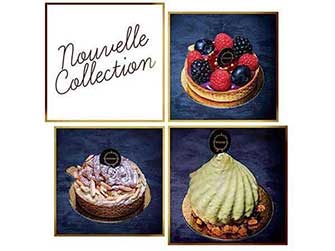 Uma seleção de pastelaria elegante e moderna das nossas Coleções Sazonais com acabamentos brilhantes e logótipos decorativos de chocolate, dispostos sobre um fundo escuro com flores brancas em primeiro plano.