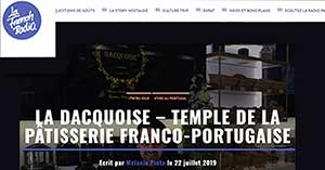 Captura de ecrã de um sítio Web que apresenta um artigo intitulado La Dacquoise - Temple de la pâtisserie franco-portugaise, com um fundo escuro e prateleiras com pastelaria e decorações, apresentando os destaques da imprensa Dacquoise.