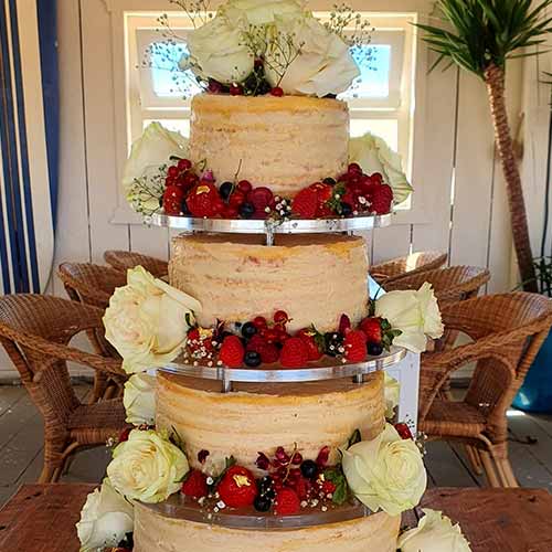 bolo de casamento com 4 andares ornamentado com flores e frutas