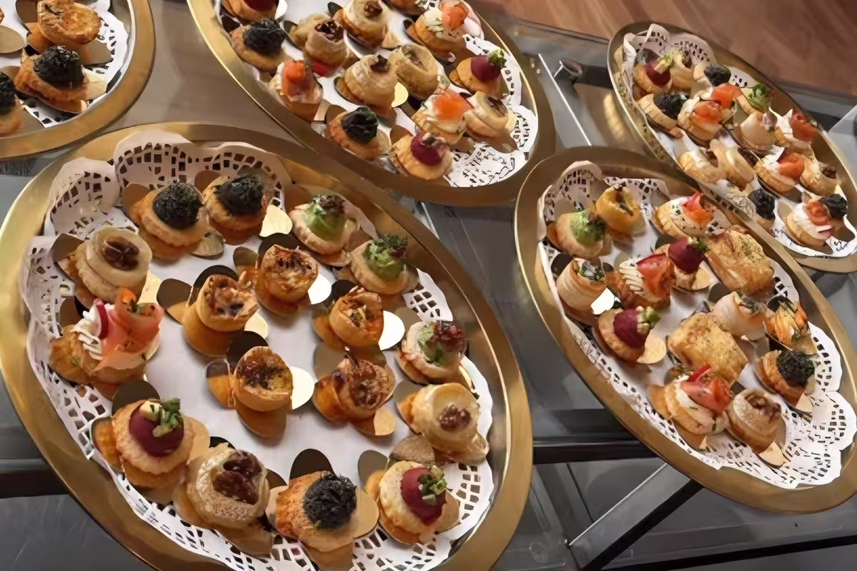 Finger food gourmet com miniaturas salgadas de salmão, presunto, humus e abacate para catering corporativo.